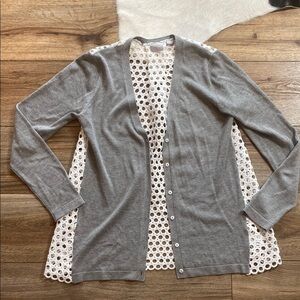 gray cardigan sweater with a white, eyelet-patterned fabric lining the back
